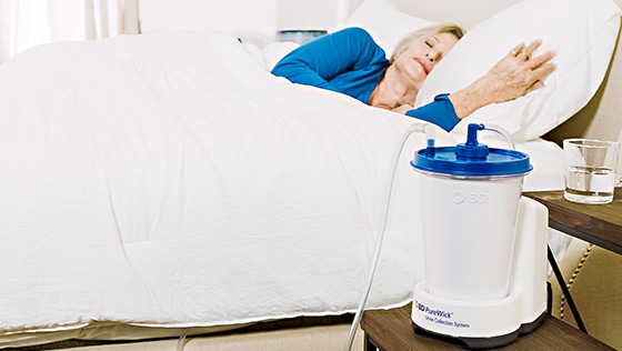 A woman in bed sleep with her Purewick on the night stand