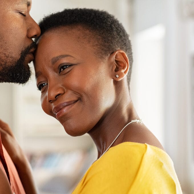 Man kissing his wife on forehead